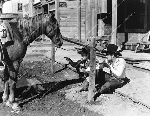 cowboy Buck Jones and buddy George Cooper launching slingshot under horse - 1932 film Forbidden Trail - 0442-032