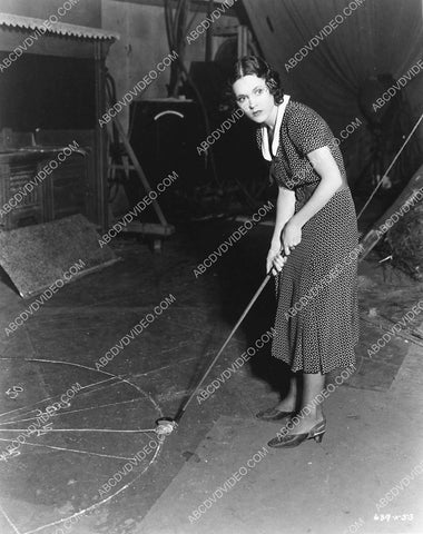 candid Maureen O'Sullivan takes her golf clubs to studio soundstage for practice 988-17