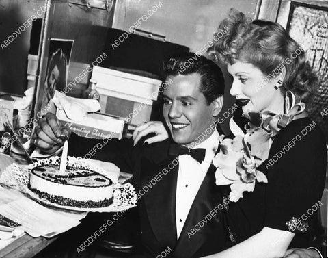 candid Desi Arnaz and Lucille Ball getting a cake in dressing room 1499-16