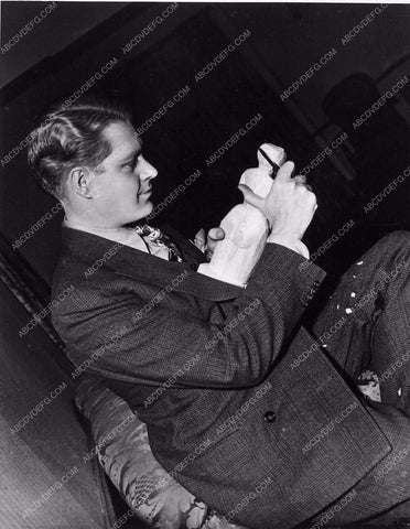 candid Nelson Eddy carving a statue for a hobby behind scenes MGM 1674-25