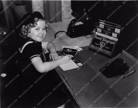 candid Shirley Temple fills out Postal Telegraph form 1684-03