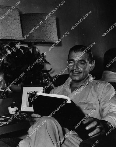 Clark Gable relaxing w a book 1909-01