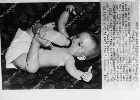 news photo baby holds milk bottle w her feet 1913-24