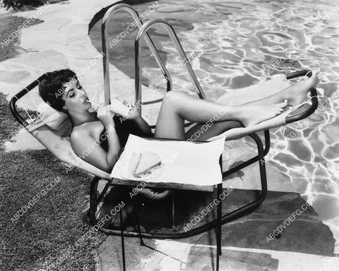 lovely Elizabeth Taylor has a sandwich and drink by the swimming pool 1974-01