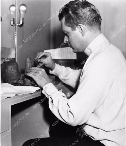 candid Nelson Eddy modeling with clay maybe in his dressing room MGM 2540-34