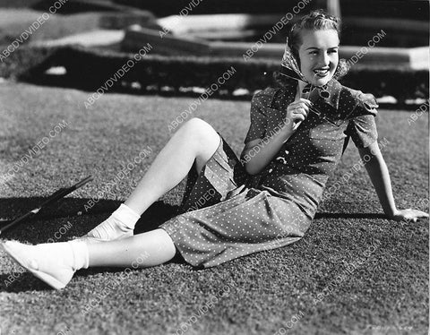 Betty Grable sitting on the grass in the sun 3030-34