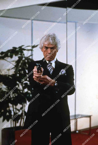 James Coburn w his pistol film Looker 35m-14444