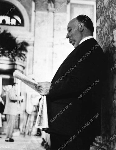 candid Alfred Hitchcock reading the newspaper 4658-15