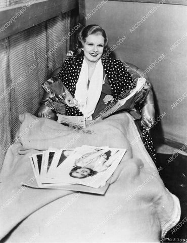 candid Jean Harlow w script in one hand, going through photos w other 4721-28