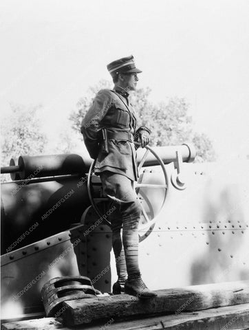 Gary Cooper poses in front of cannon 5795-09
