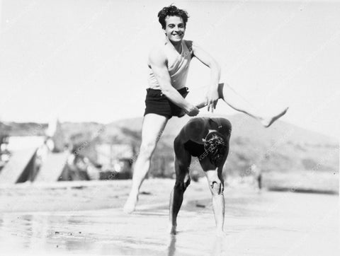 beefcake Ramon Novarro playing leap frog on the beach 6032-18