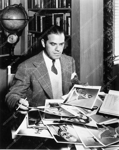 director Frank Capra looking over photos in his office 6076-21