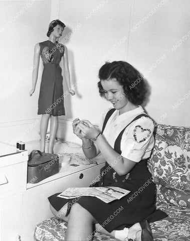 Shirley Temple dressing her doll in her dressing room 6114-29