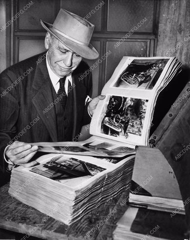 Mack Sennett going through a large photo scrapbook  6269-27
