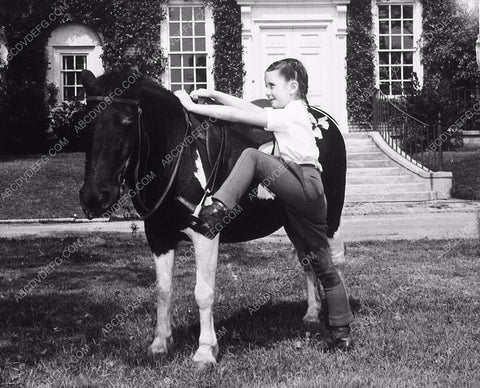 candid Margaret O'Brien mounting her pony 8969-32