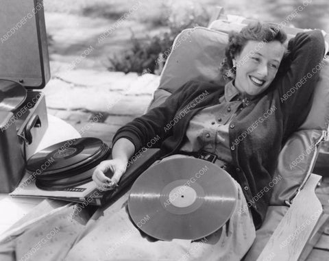 Phyllis Thaxter relaxes with record player after stricken w Polio 8b6-574