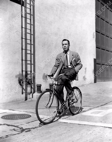 Humphrey Bogart riding bicycle on studio backlot 8b20-14030