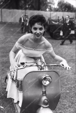 Gina Lollobrigida riding around on a Vespa scooter 8b20-16923