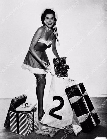 cute Ann Miller helps fill up Santa's bag for Christmas dp-2369