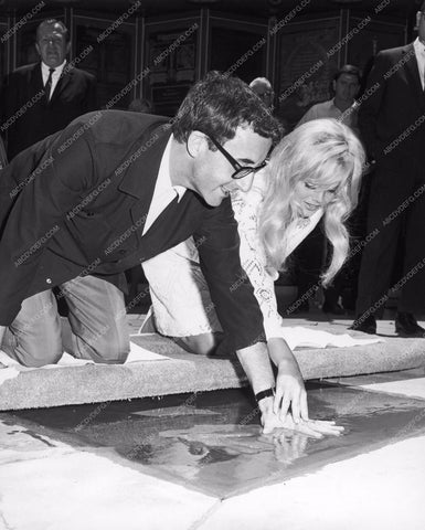Britt Ekland helps Peter Sellers put hands feet in cement Grauman's Chinese 8b20-5419