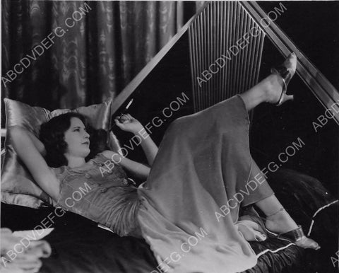 Barbara Stanwyck laying down with cigarette holder 8b20-7234