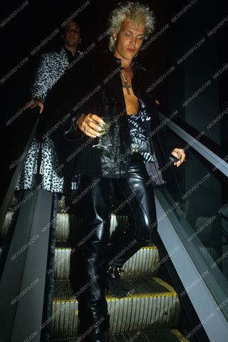 Billy Idol on an escalator with drink in hand 8b20-7936
