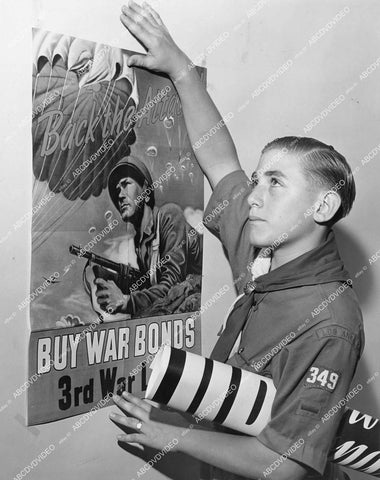 crp-11965 1943 news photo WWII boy scout Irving Wexler places US War Bonds posters around town crp-11965