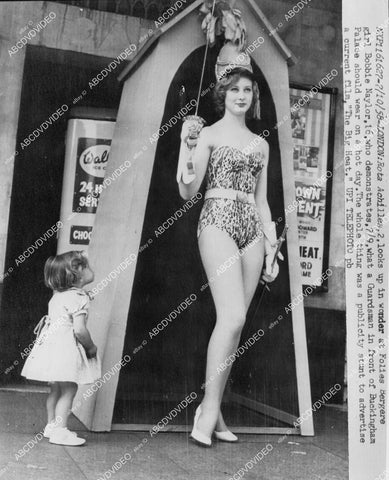 crp-00841 1958 Folies Bergere dancer Bobbie Naylor demonstrates what Guardsman Buckingham Palace should wear crp-00841